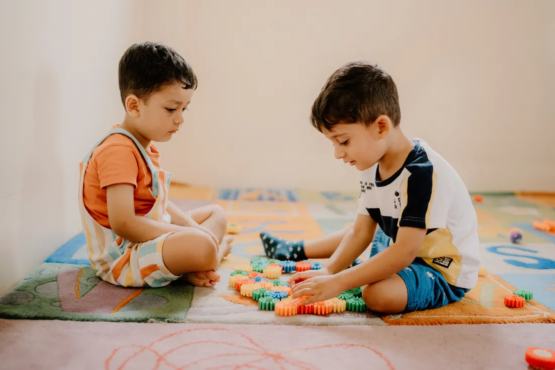 Two children playing with colourful construction toys