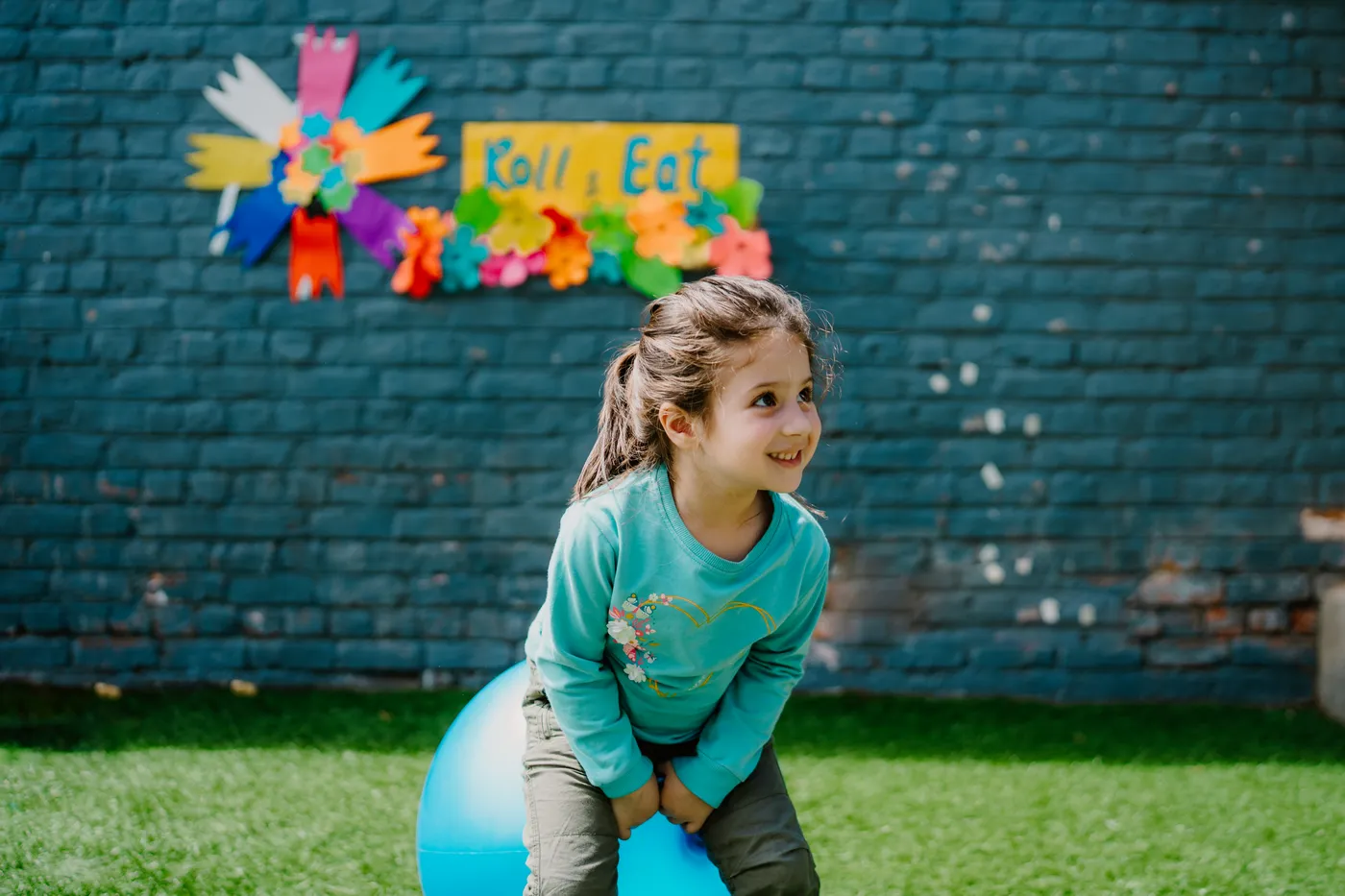 A girl bouncing on a space hopper in the garden