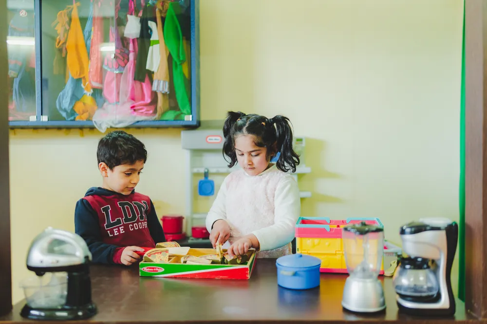 Children playing with role-play toys at the toy kitchen