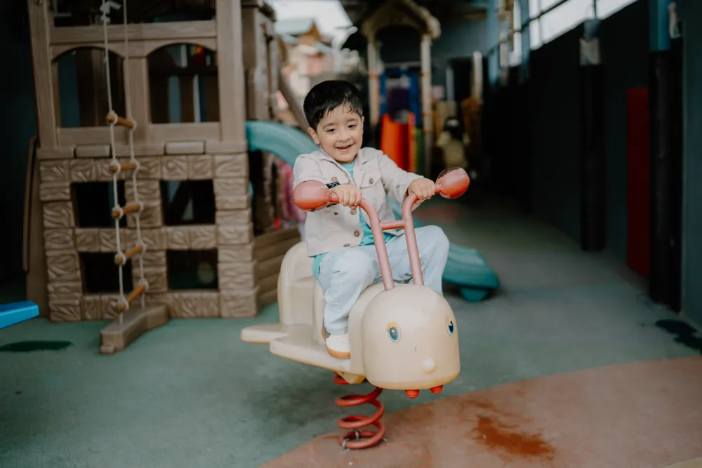 A child riding a spring rocker in the outdoor play area
